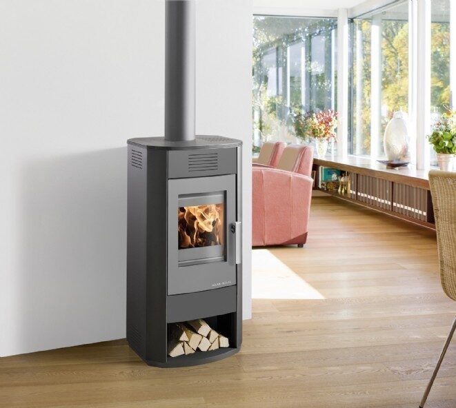 Moderner Kamin, der Boden ist aus Holz und im Hintergrund sieht man rosa Möbel des Wohnzimmers