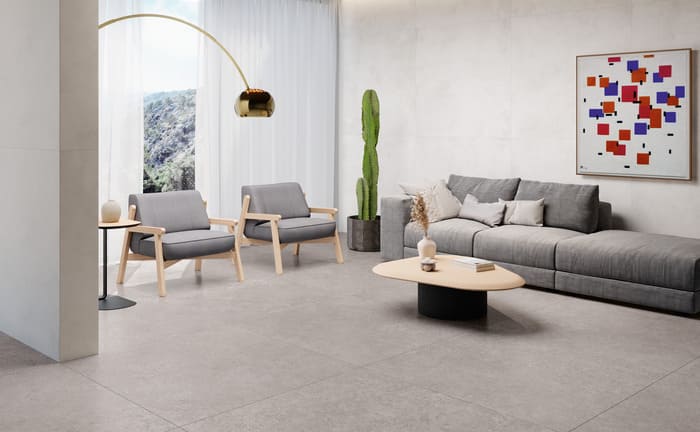 Moderner Wohnbereich mit großen grauen Fliesen, moderner Kunst und grauen Möbeln